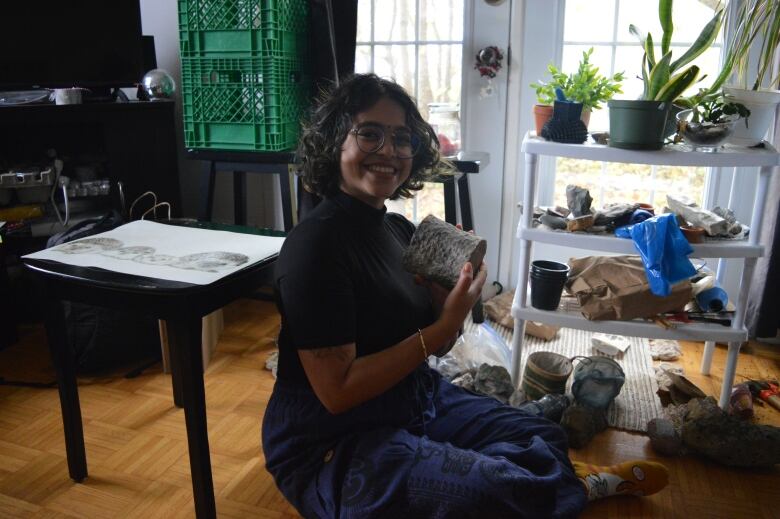 Woman holds up rock, smiling