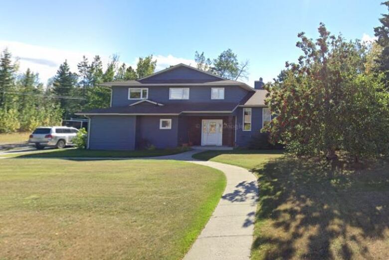 A blue house is seen from the street.