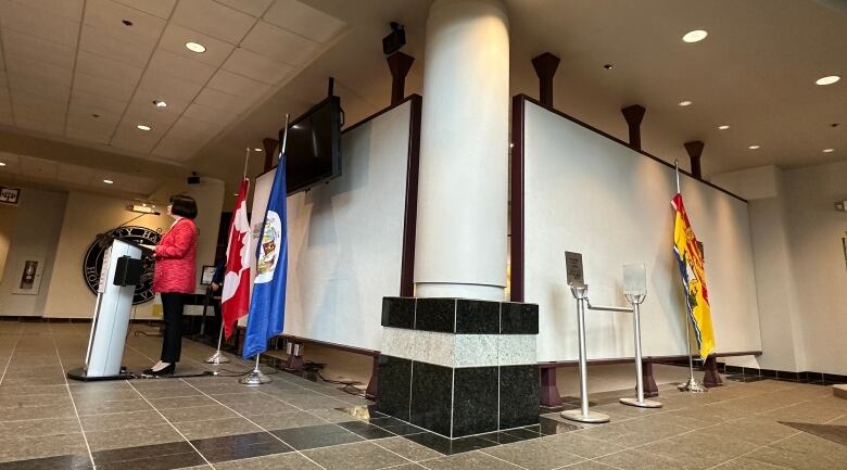 A podium and flags on the left with the New Brunswick flag around a corner on the right.