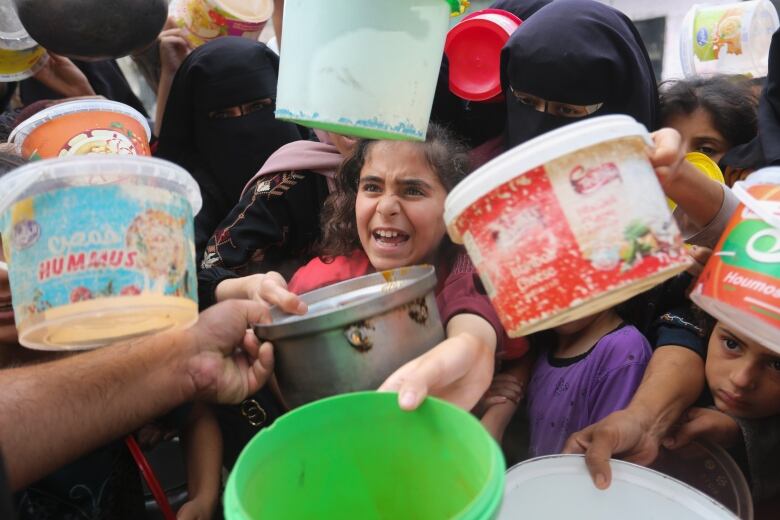 Palestinians line up for food during the ongoing Israeli bombardment of the Gaza Strip in Rafah.