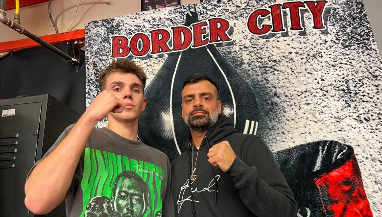 Jayden Trudell and Andre Gorges pose together in front of a sign that says Border City