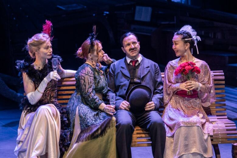 a scene from the the play Sointula shows three women and a man sitting on a bench