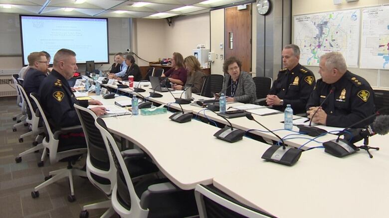 People in police uniforms are sitting at a table in a room