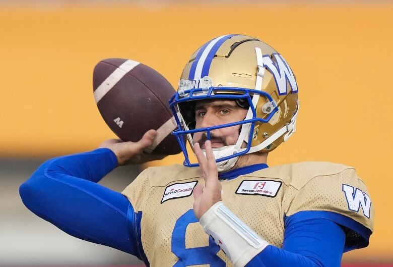 A football player throws a football.