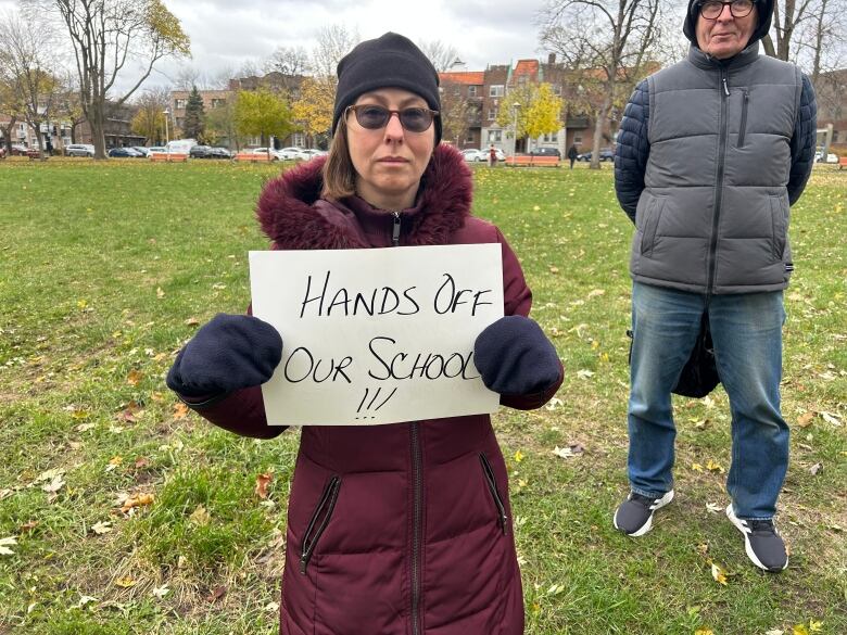 A woman holds up a sign reading, 