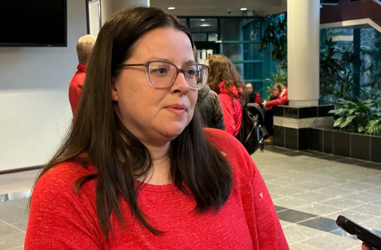 A woman in red wearing glasses. 