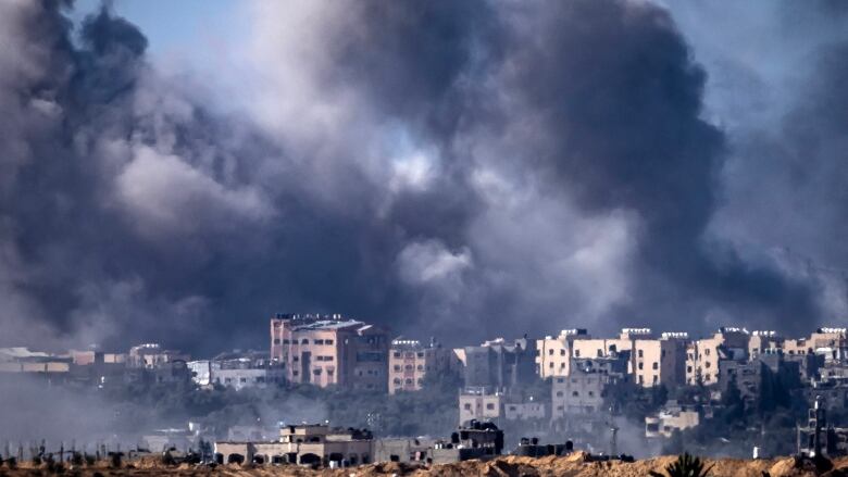 Smoke billows behind buildings following an airstrike.