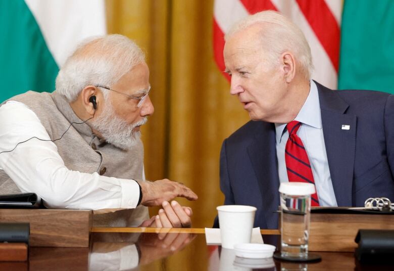 Biden and Modi chatting closely, seated at a table