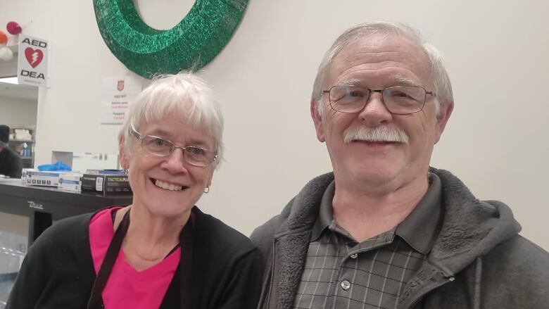 An elderly couple standing next to each other