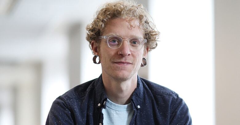 a portrait of a person with blonde hair and glasses