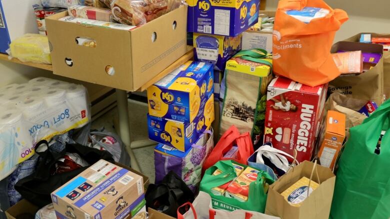 Food and toiletries are stacked in piles for a charitable food drive.