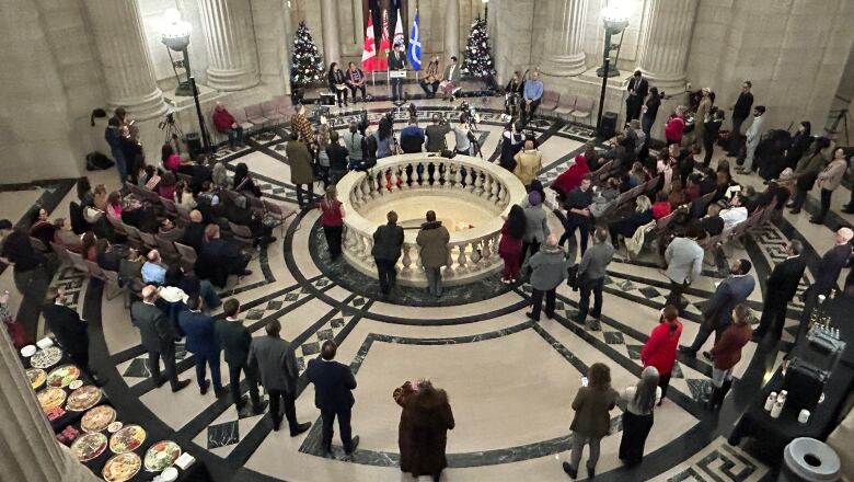 A crowd of people are seen gathered to listen to a speech.