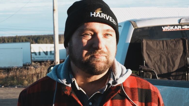 A closeup shot of a man wearing a tuque that says 