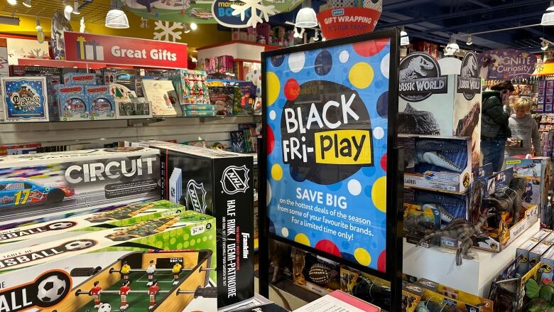 Boxed games are stacked on shelves during a toy store's Black Friday sales event.