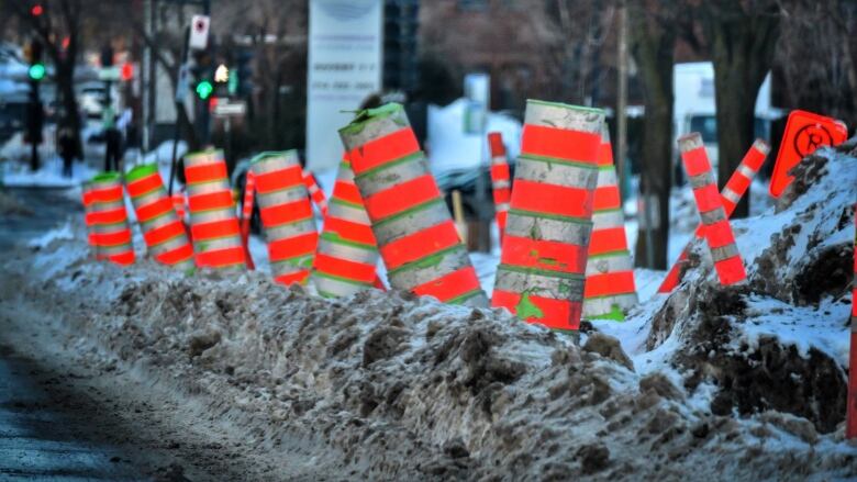 Traffic cones in a snowbank.