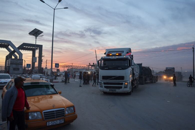 Trucks carrying humanitarian aid enter the Gaza Strip via the Rafah border crossing.