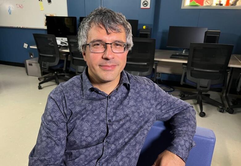 A man at an office in a blue shirt.