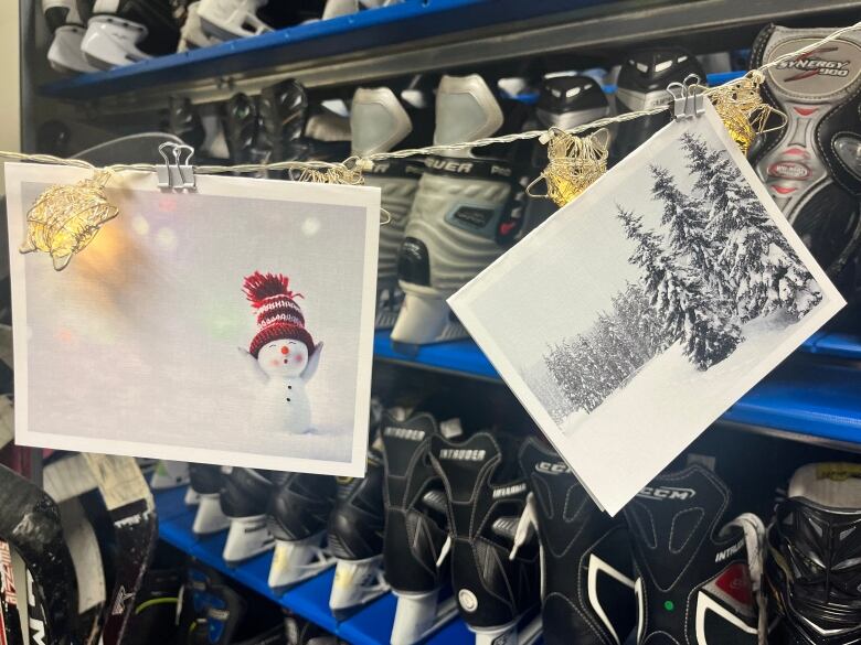 Two winter themed greeting cards hand in front of hockey gear.