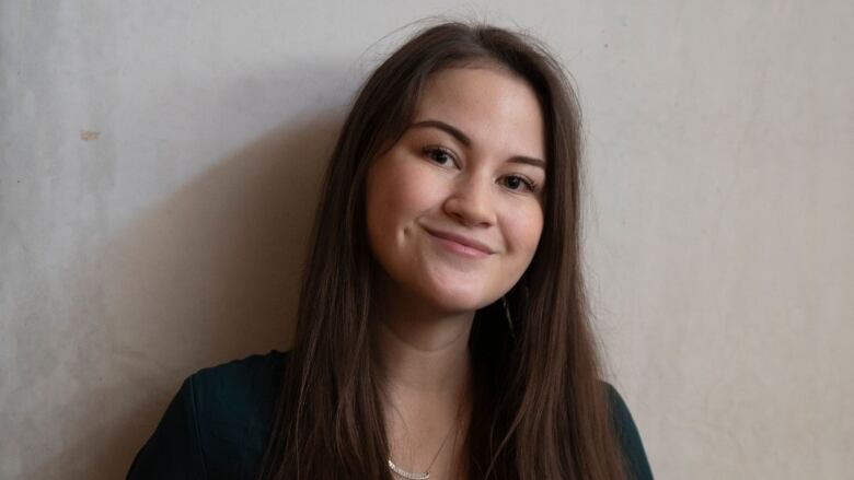 A portrait shows a young woman with long dark hair smiling at the camera.