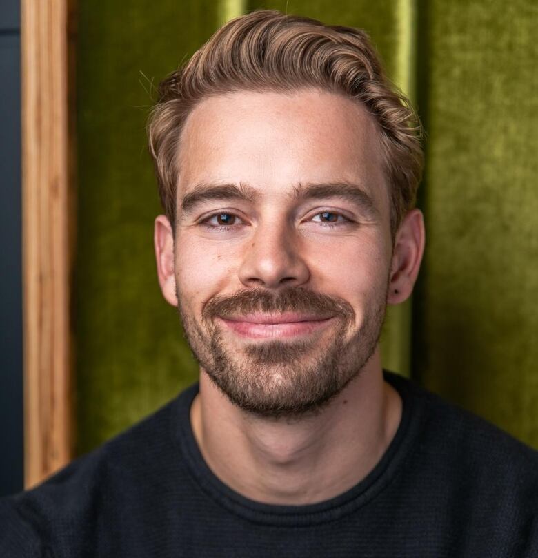 a man with a beard in a black shirt