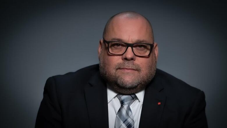 A man in a suit and glasses.