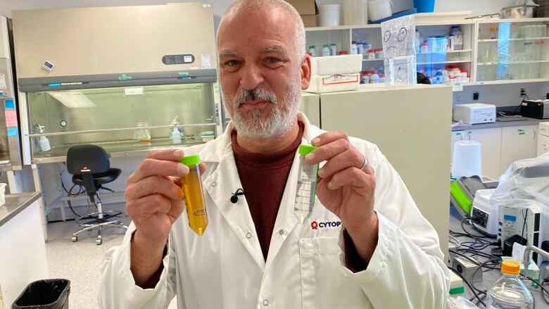 Cytophage owner and researcher Steven Theriault holds two vials of fluid - FarmPhage was added to the clear one, killing the bacteria inside. He believes he has the solution to an urgent global public health threat  antibiotic resistance.