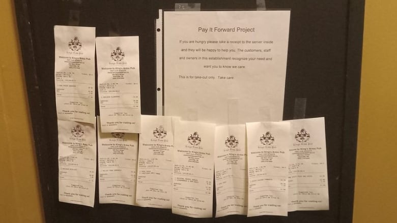 Receipts from prepaid meals line the door at the King's Arms Pub in Kentville. Anyone in need of food can take one and get a free meal from the restaurant.