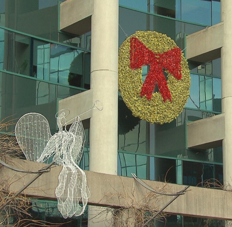 Large Christmas wreath and ornamental angels on front of building. 