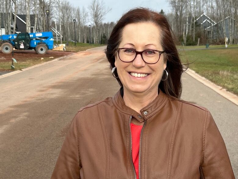 Woman stands on street of a new housing development.