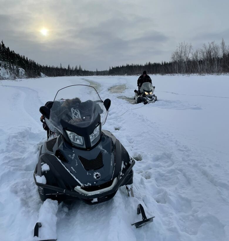 two skidoos on a frozen river.