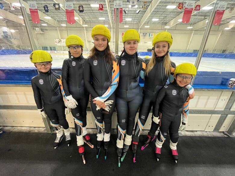 Kids in speed skating uniforms pose for a picture at Yellowknife's Multiplex.