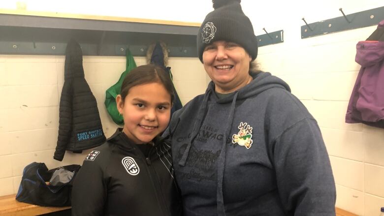 Woman and child pose for picture in ice rink locker room