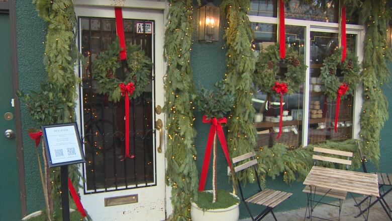 A cafe front decorated in christmas decorations. 