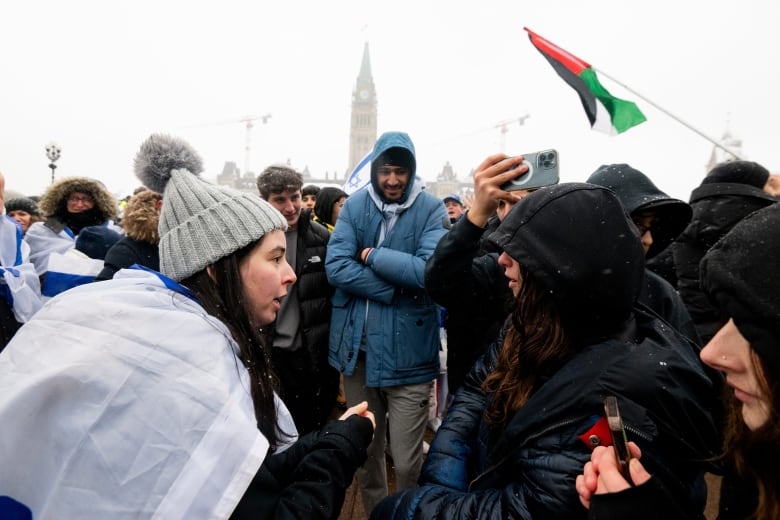 Pro-Israel protesters, left, argue with pro-Palestinian protesters during a pro-Israel protest near Parliament Hill in Ottawa on Monday, Dec. 4, 2023.