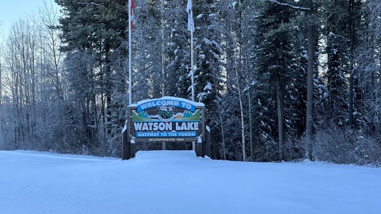 A sign in the snow reads, 'Welcome to Watson Lake.'