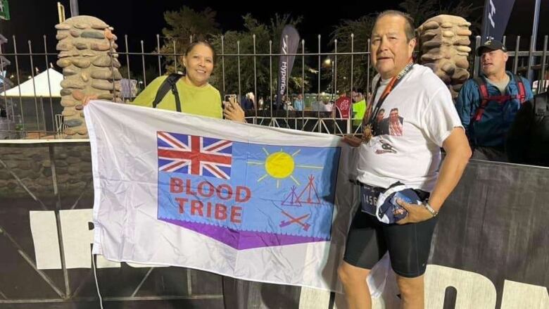 Troy stands next to his wife at the finish line of the Ironman. 