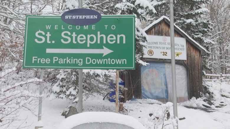 A welcome to St. Stephen sign with a tarped over wooden building behind it