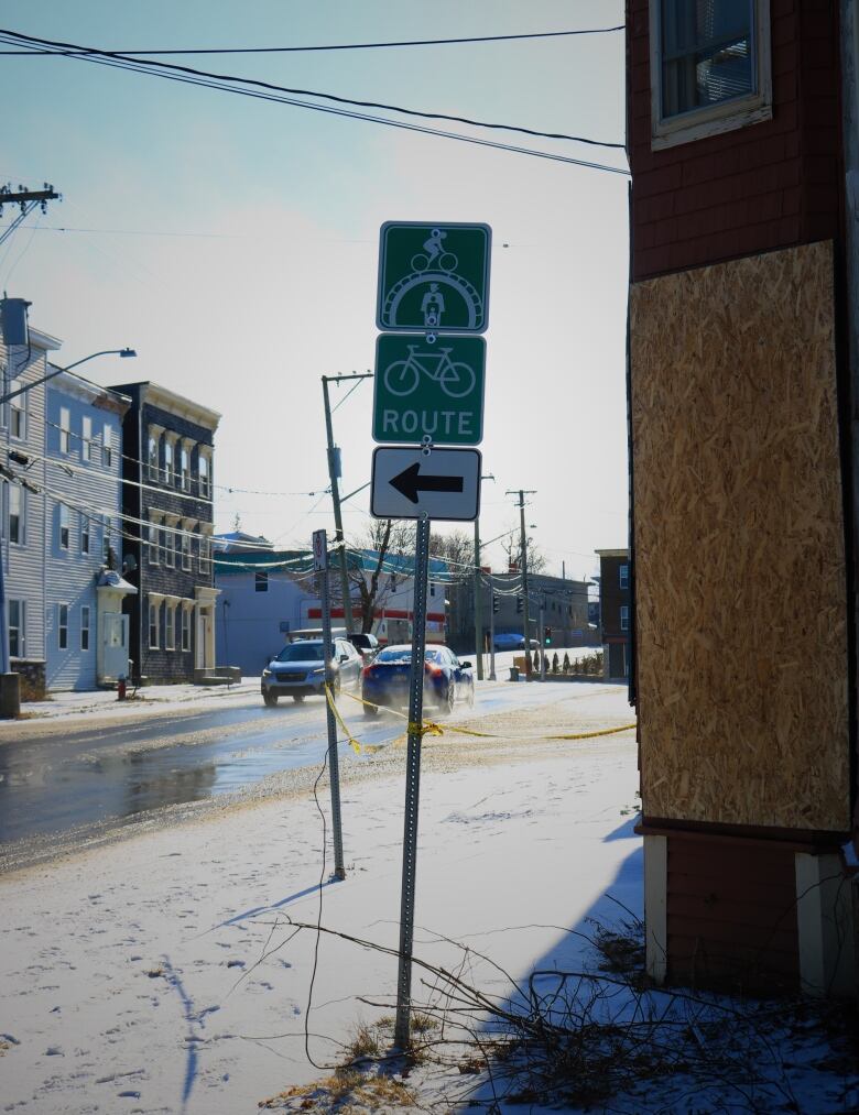 A bike route sign on a busy winter street. 