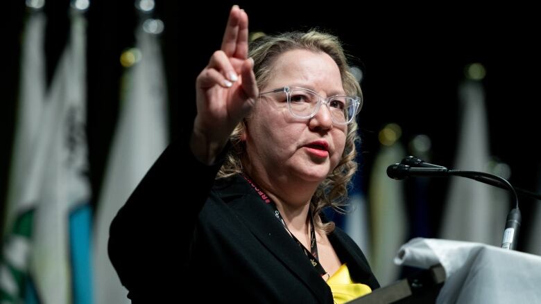 A woman raises her hand during a speech.