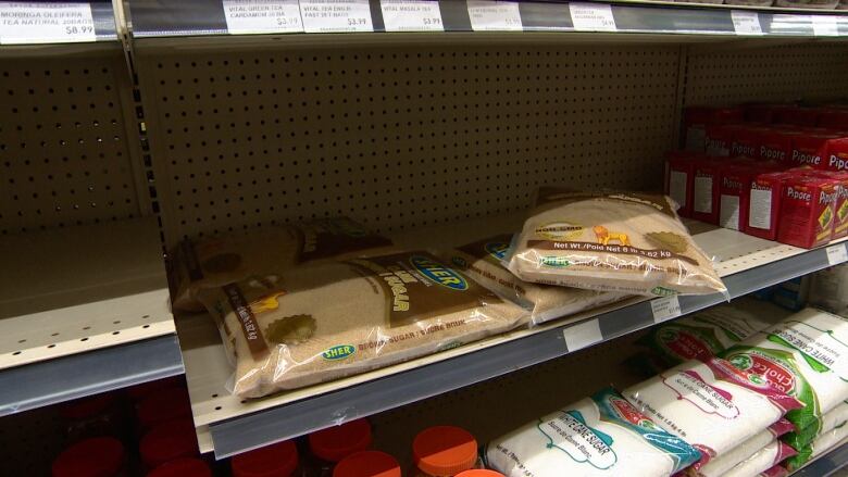 Packs of brown sugar can be seen on a shelf in a grocery store