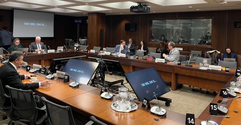 A conference table and people sitting.