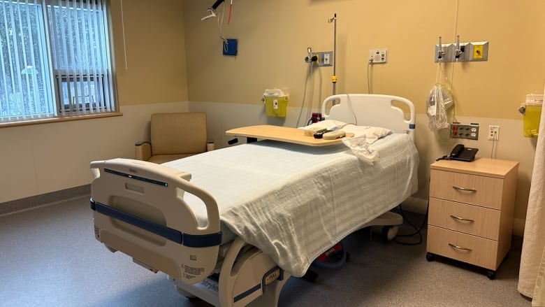 A bed in an empty hospital room.