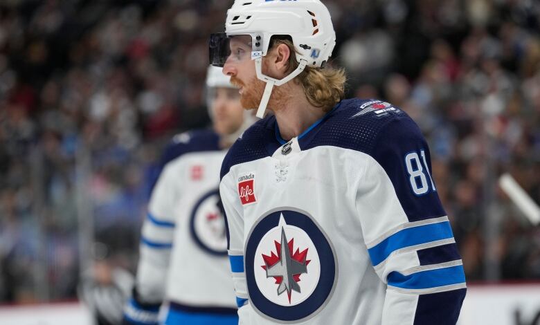 A hockey player in a white and blue uniform