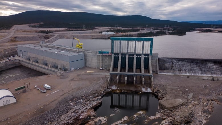 A hydroelectric dam on a calm river in autumn.