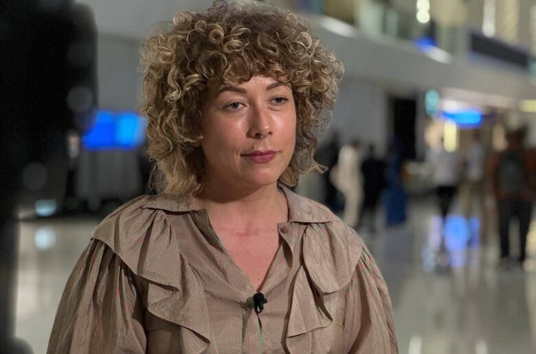 A woman is interviewed at a conference centre.