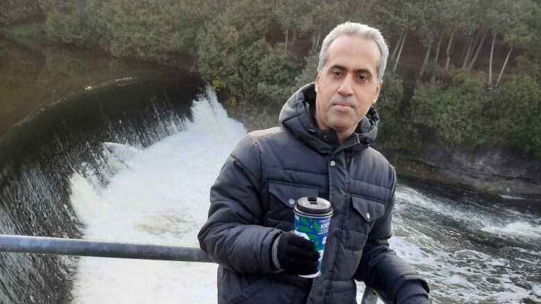 Photo of Sofyan Taya in front of a waterfall. 