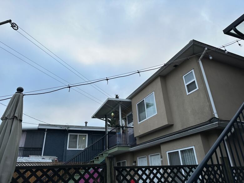 A picture of a backyard shows a light cable with about 6 missing light bulbs. 