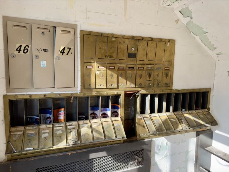 A wall of open mailboxes in an apartment building. 