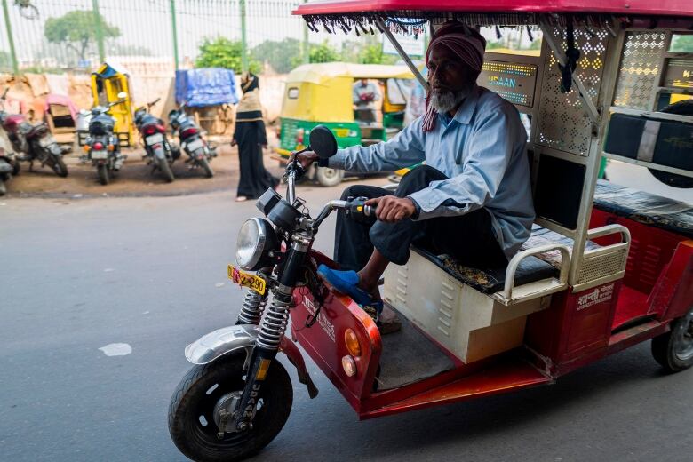 A man drives an electric rickshaw.