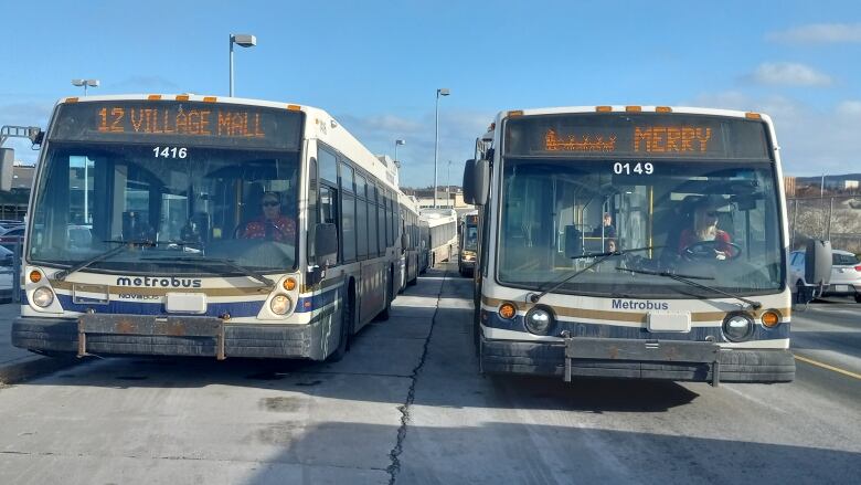 A number of buses on a road.